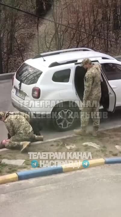 В Харькове военкомы избивают лежащего на земле парня и пытаются затолкать его в свою машину